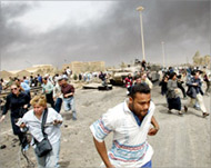 Reporters flee from a wrecked tank as US jets fly overhead 