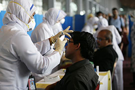 Malaysia's health officials check temperatures of passengers arriving from the US at Kuala Lumpur airport