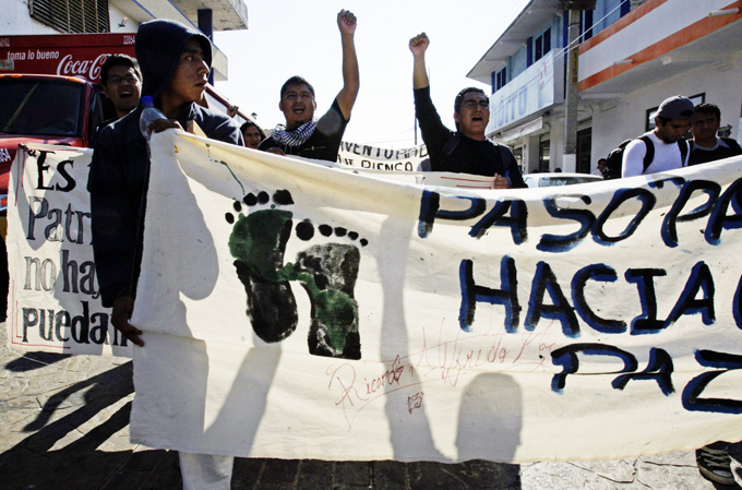 Migrants from Guatemala carry a banner during a march to raise awareness of violence towards migrants in Arriaga