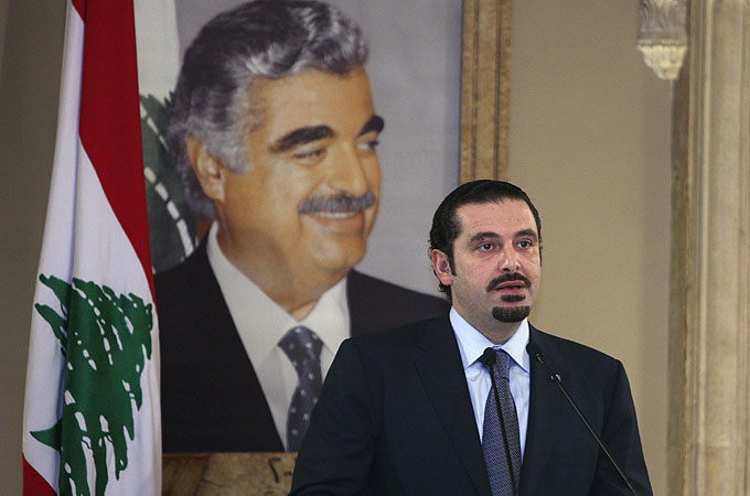 Saad Hariri standing in front of poster of his father, late Rafik Hariri