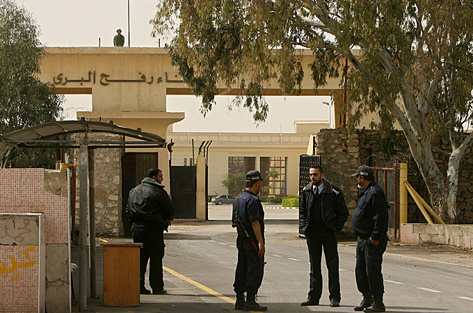 A picture taken on February 19, 2011 shows an Egyptian soldier (top) keeping watch on the Egyptian side of the Rafah border crossing as Hamas policemen stand guard on the Palestinian side