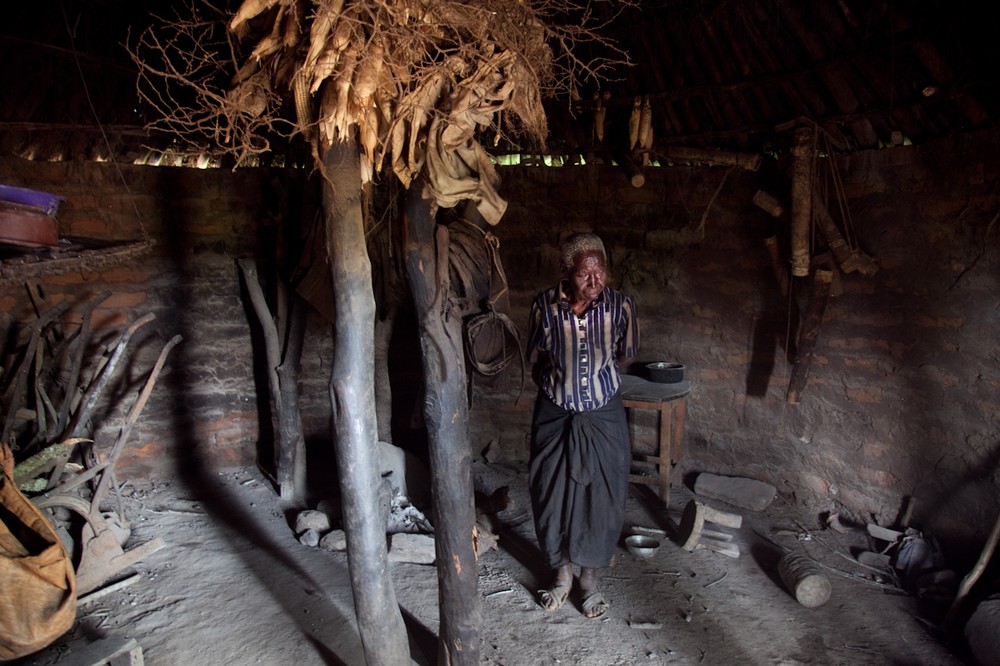 Naomi Kimweli stands in her kitchen outside the town of Katangi, Kenya. Naomi lost her unborn baby and three young children when her bus was stopped by colonial officers in 1957.