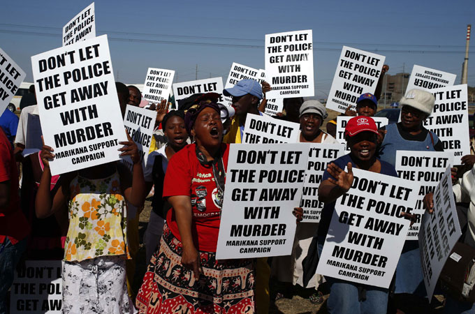 Protesters wave placards as Marikana investigation gets underway