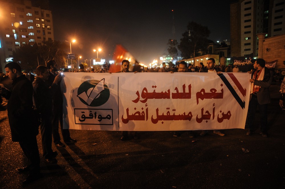Members of the Muslim Brotherhood march with a banner that reads, "Yes to the constitution, for a better future" in Nasr City, Cairo. Rival sides in Egypt are staging rallies a day before the first round of voting begins on a contentious draft constitution.