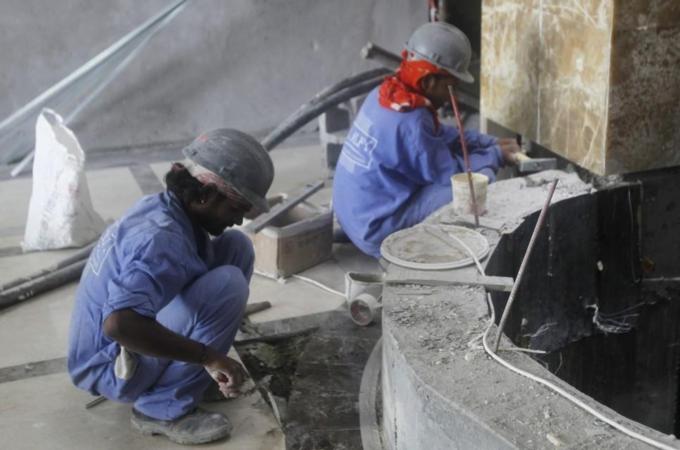 Labourers work at a construction site in Doha