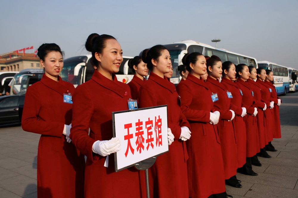 A group of hostesses pose in front of buses at Tiananmen Square in Beijing. The congress will complete China(***)s leadership transition that began with a Communist Party congress in November 2012.