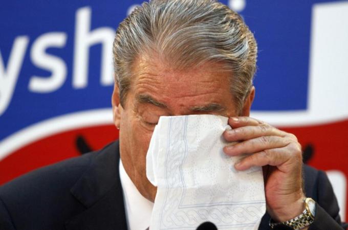 Albania''s PM Berisha wipes his tears during a news conference in Tirana
