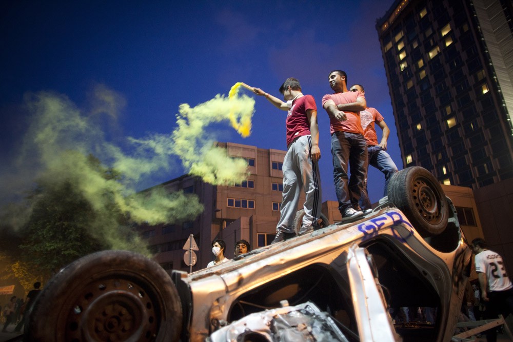 <p>A young man stands on top of a burnt car in Taksim Square. The square, located across from Gezi Park, has been referred to Turkey(***)s Tahrir Square by some commentators. The government says such a reference is absurd as Turkey is a democracy and Egypt was a dictatorship during the Tahrir protests. </p>