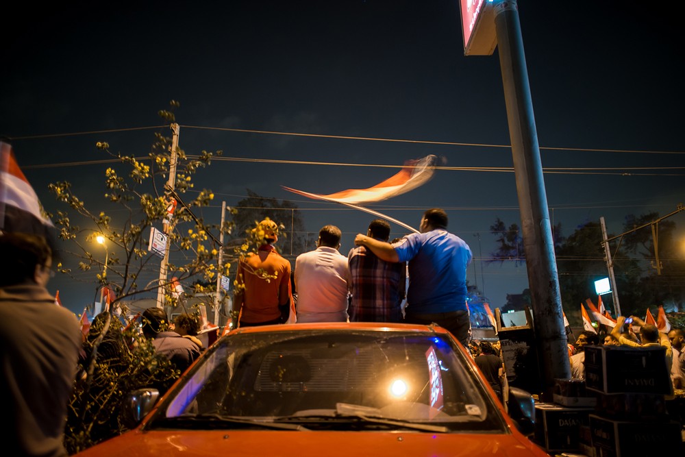 Anti-Morsi protesters observe a march near the presidential palace