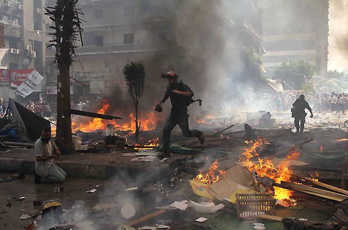 Reporters run for cover during clashes between Muslim Brotherhood supporters and police in Cairo on August 14, 2013 [File: Mosaab el-Shamy/AFP]