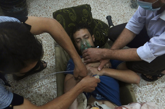 A man, affected by what activists say is nerve gas, breathes through an oxygen mask in the Damascus suburbs of Jesreen