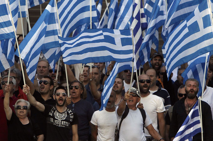Supporters and members of extreme-right Golden Dawn party hold Greek national flags as they sing the national anthem outside the Greek police headquarters in Athens September 28, 2013 [Al Jazeera]