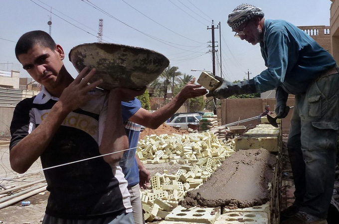 Iraqi workers build a private school in Baghdad on April 24, 2012. The Ministry of Education announced in February that Iraq needs 6,000 new schools to absorb the current number of students, but according to the allocated budget building this many public schools will take 20 years. [AFP]