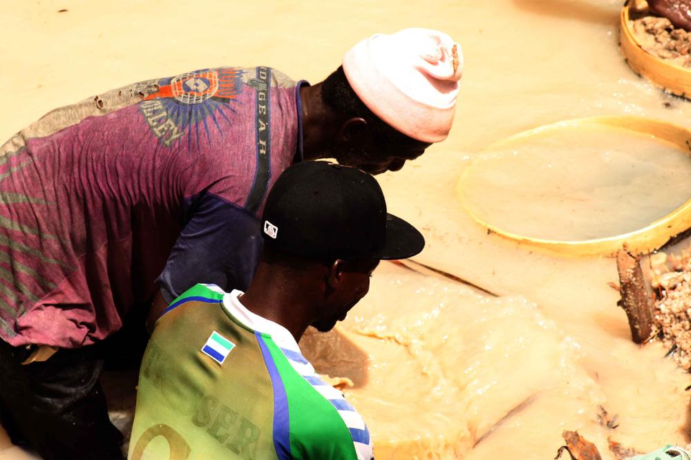 Pa Abou Conde and his son search through gravel for diamonds.