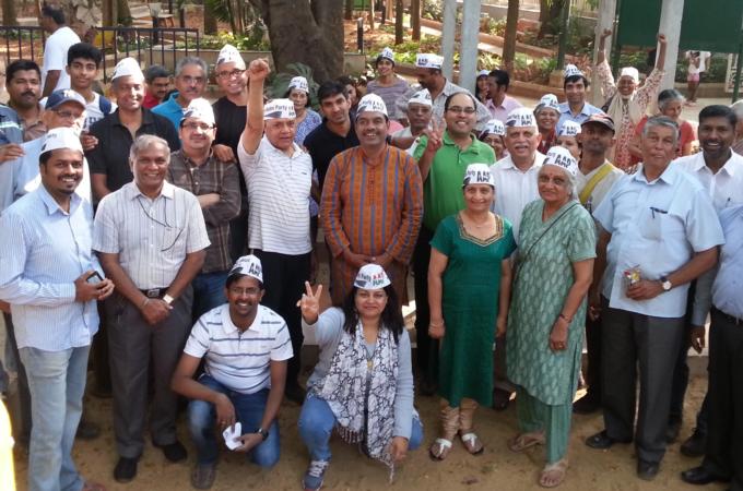 Balakrishnan, (centre in orange), a former IT executive, is running on an AAP ticket [Lavanya Singhal/ Al Jazeera]