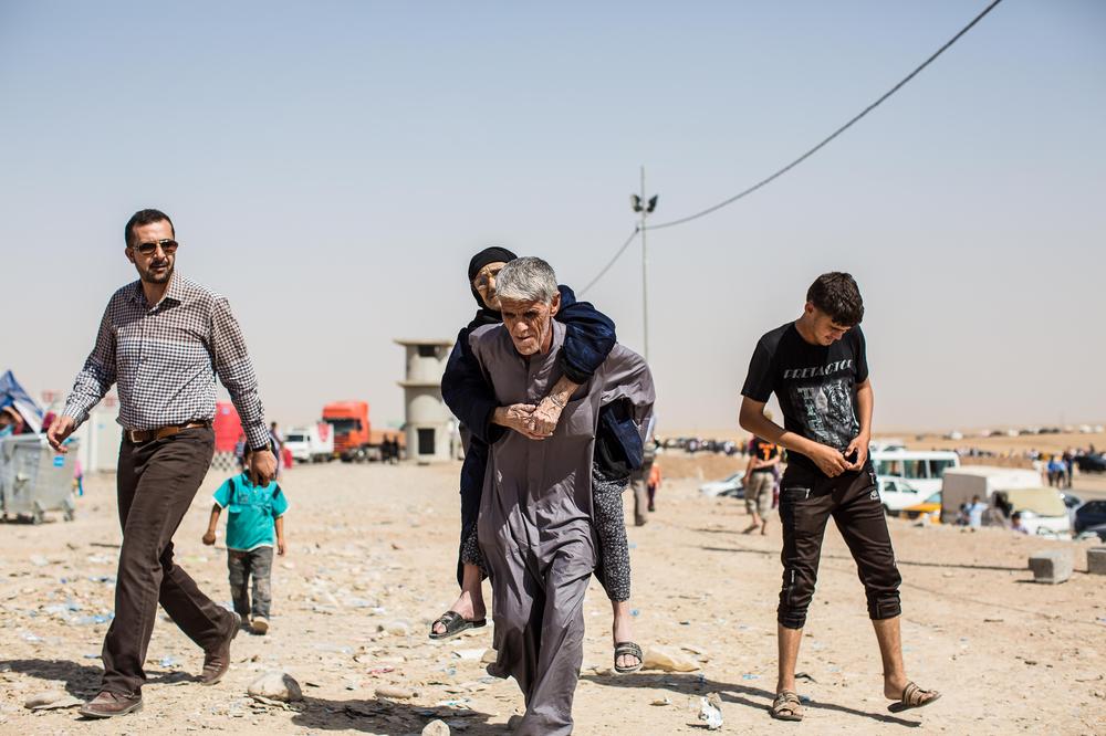 An elderly Iraqi woman is carried to the registration point of Khazer camp.