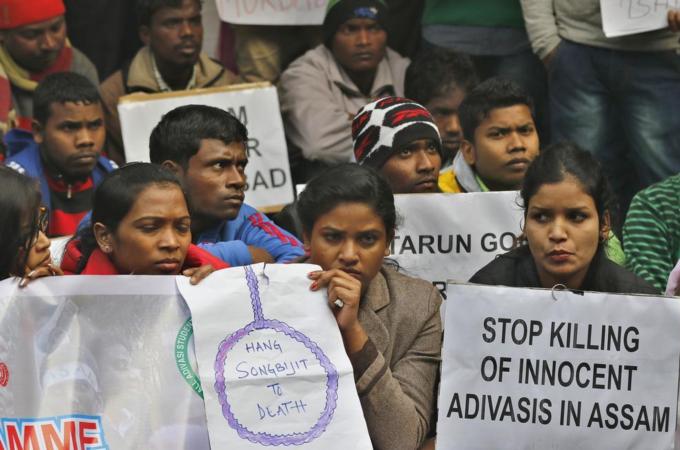 Members of All Adivasi Students Association of Assam ( AASAA ) shout slogans and hold placards during a protest against the recent killings in Assam carried out by NDFB militants [Getty Images]
