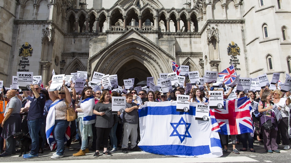 People hold placards and Israeli and Union flags