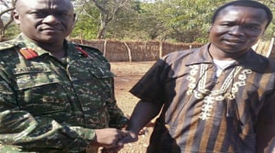 After his surrender, Lord's Resistance Army commander Dominic Ongwen poses with the Ugandan soldier [Associated Press]
