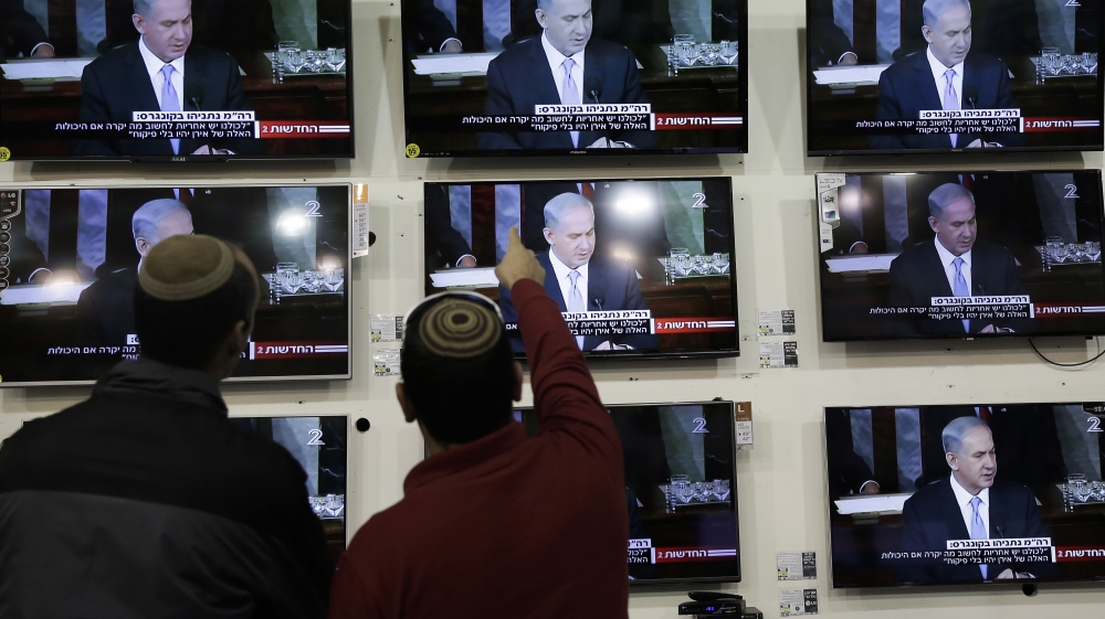 Israelis watch Netanyahu address the US Congress in a shop [AP]