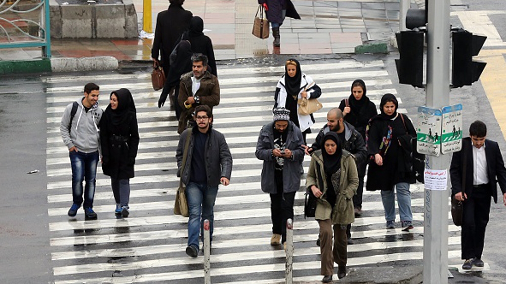 Iranians walk on a street in the capital Tehran [Getty]