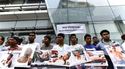 Relatives of arson victims attend a rally holding photographs of family members as they protest the attacks [EPA]