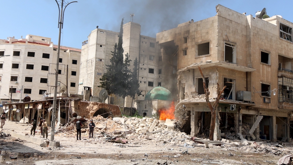 Residents inspect a fire at a damaged site after what activists said was shelling by forces loyal to Assad in Idlib [REUTERS]