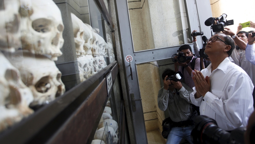 Rainsy (R), President of the CNRP prays in front of the skulls and bones