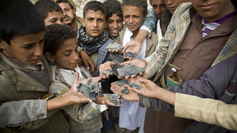 Yemeni boys display shrapnel they collected from the rubble of houses destroyed by airstrikes in a village near Sanaa [AP]