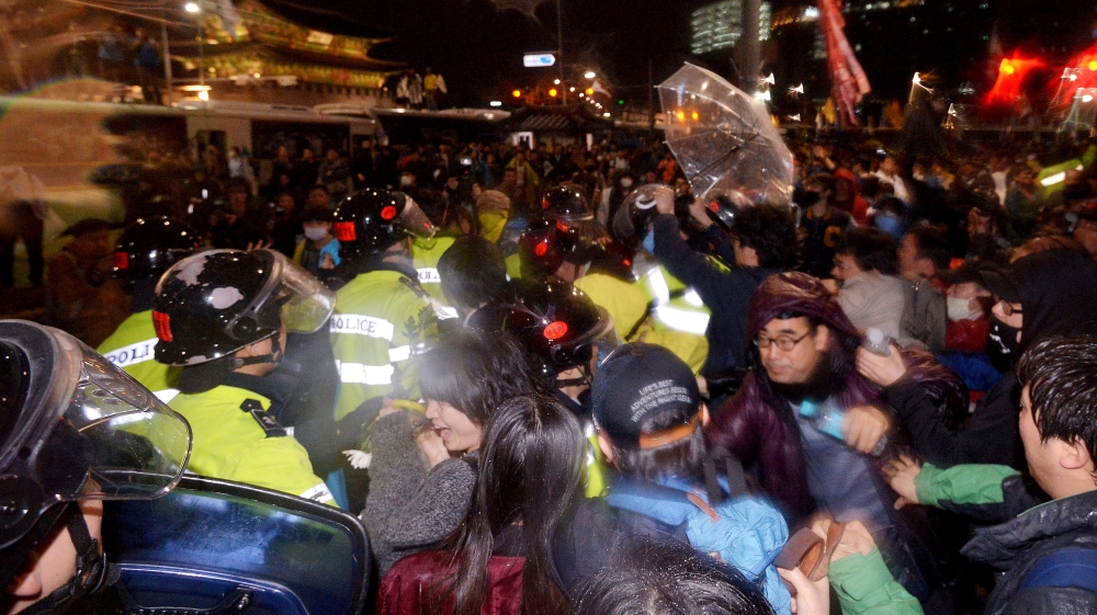 Protesters clashed with police officers after a rally to commemorate the first anniversary of the Sewol ferry sinking in Seoul [Park Dong-wook/AP]