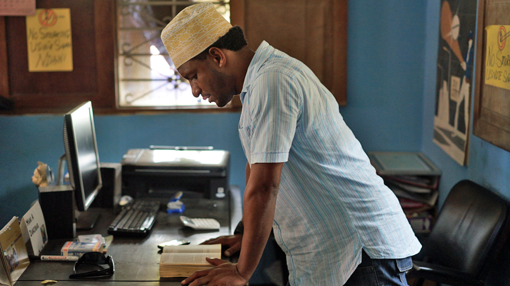 Abdulrahman Abdullah reads from Narcotics Anonymous during a 12-step meeting in Zanzibar [Abigail Higgins/Al Jazeera]