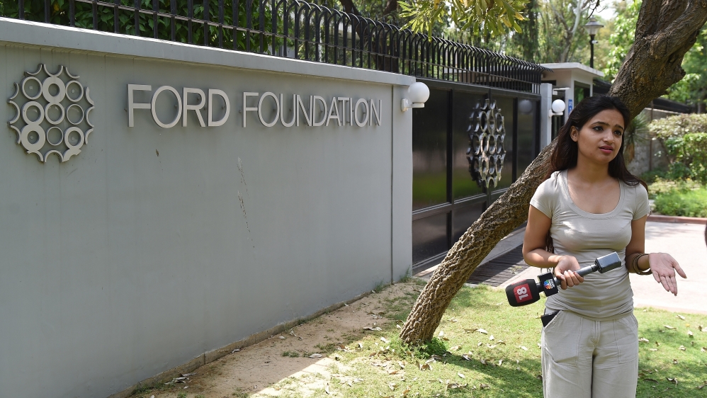 An Indian television journalist reports outside the office of the Ford Foundation in New Delhi [AFP]