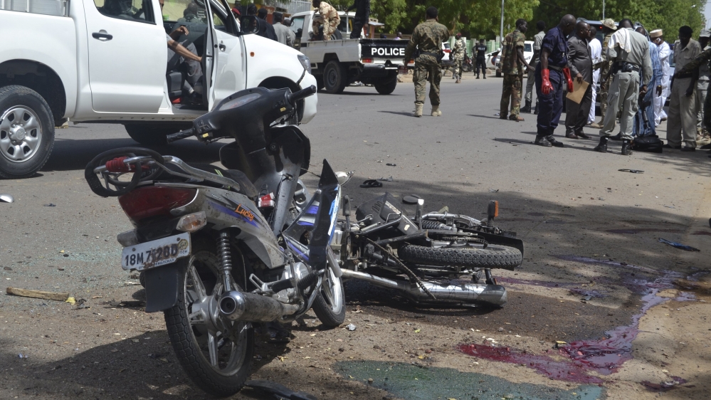Security officers stand at the site of a suicide bombing in Ndjamena