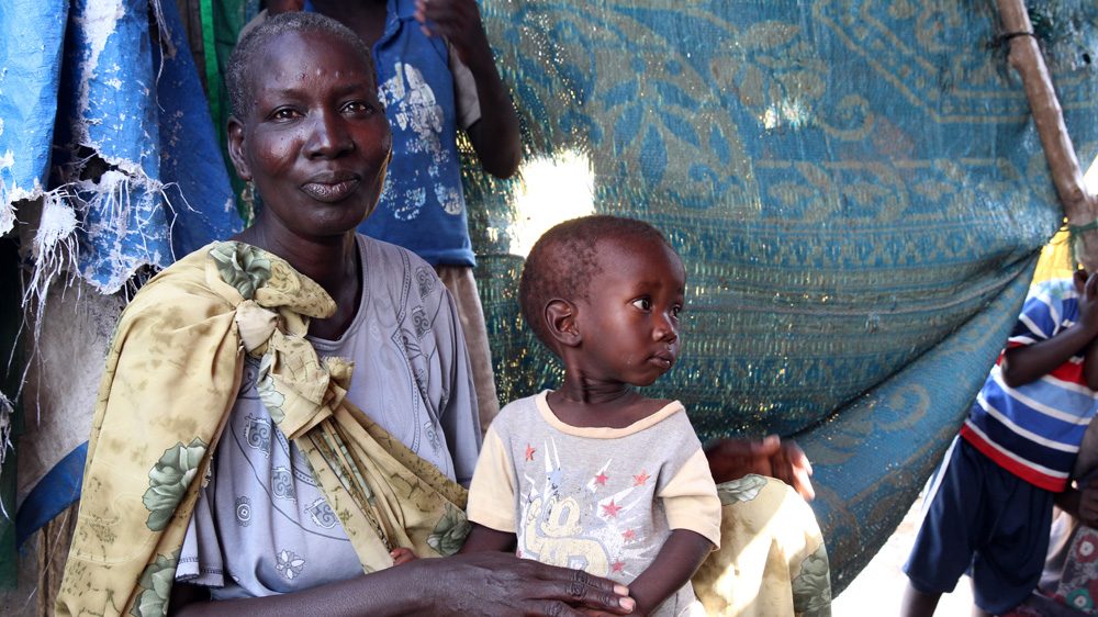 Daak Sheta at the UN camp in Malakal with her orphaned two-year-old grandson [Simona Foltyn/Al Jazeera]