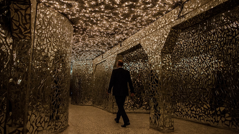 A Kurdish man walks through the Hall of Mirrors in Sulaymaniyah's Red Museum. Named after the red facade of the main building, the museum is housed on the old site of Saddam's notorious Mukhabarat intelligence service where thousands of Kurds were imprisoned and tortured. One-hundred-and-eighty-two-thousand pieces of broken glass line the Hall of Mirrors - one for each victim of Saddam's Anfal campaign, and 4,500 lights dot the ceiling - one for each Kurdish village destroyed under his reign [Mackenzie Knowles-Coursin]
