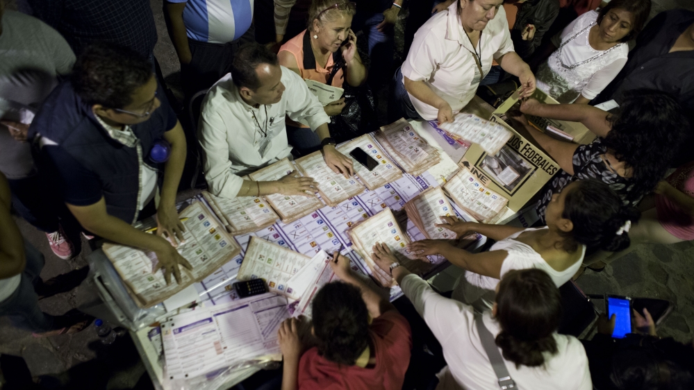 Poll workers count ballots underneath a street lights, at an outdoor poling station in Chilpancingo, Guerrero State, Mexico [AP]