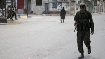 Members of Nusra Front walk along a street in the northwestern city of Ariha in Idlib province [REUTERS]