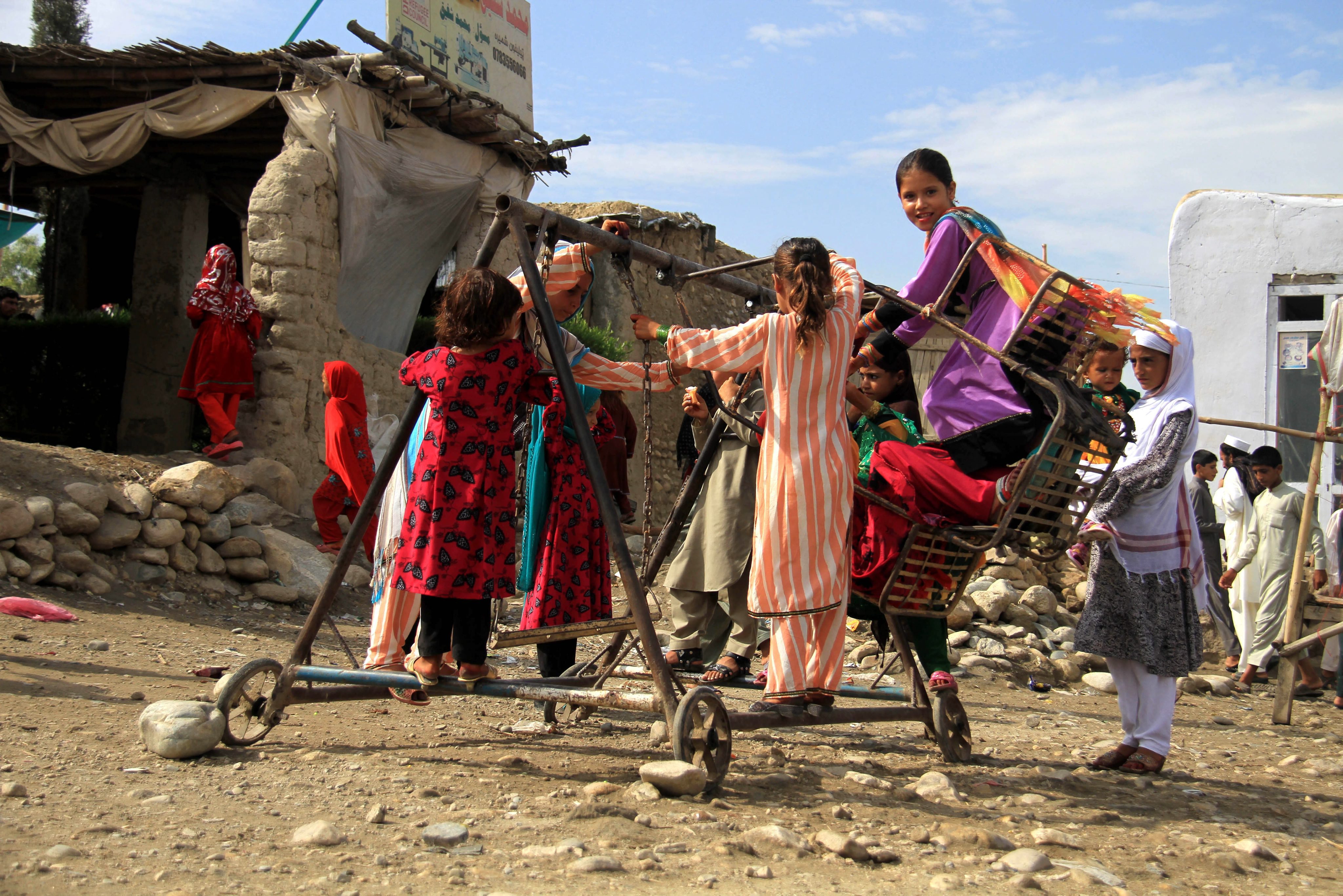Afghan children enjoy the ride on a carousel to celebrate Eid al-Fitr, in Jalalabad, Afghanistan, 17 July 2015.