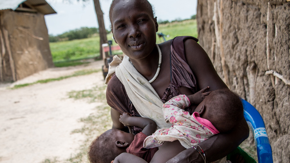 Nyangor Kuil cradles her twins having safely arrived in Fangak [Ashley Hamer/Al Jazeera]