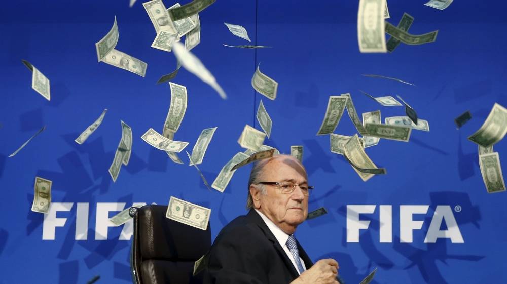 British comedian known as Lee Nelson (unseen) throws banknotes at FIFA President Blatter as he arrives for a news conference after the Extraordinary FIFA Executive Committee Meeting at the FIFA