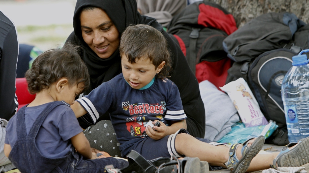 Refugees rest in a park beside the main railway and bus station after arriving in Belgrade, Serbia [EPA]