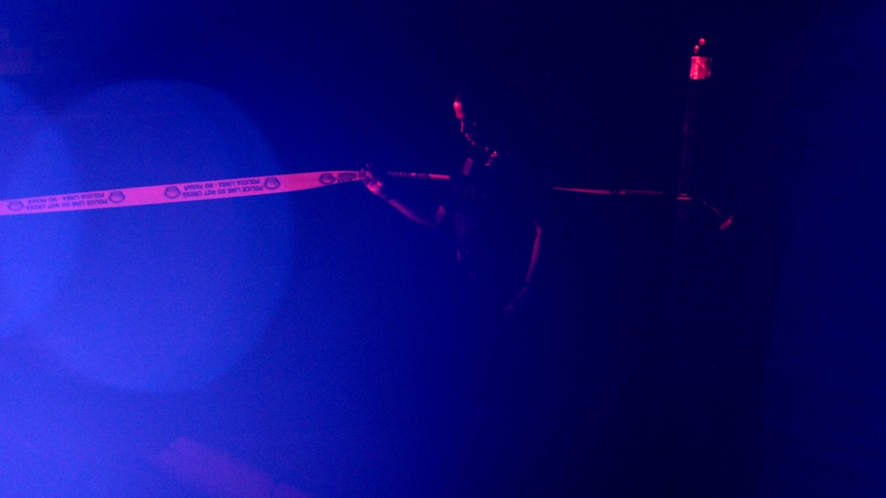 An APD officer hangs crime-scene tape to block off a road during a SWAT standoff in May 2015 [Andy Beale] 