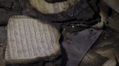 Burned pages of the Quran lie on the floor of the Dawabsheh home, which was targeted in an arson attack by Israeli settlers [Ash Gallagher/Al Jazeera]