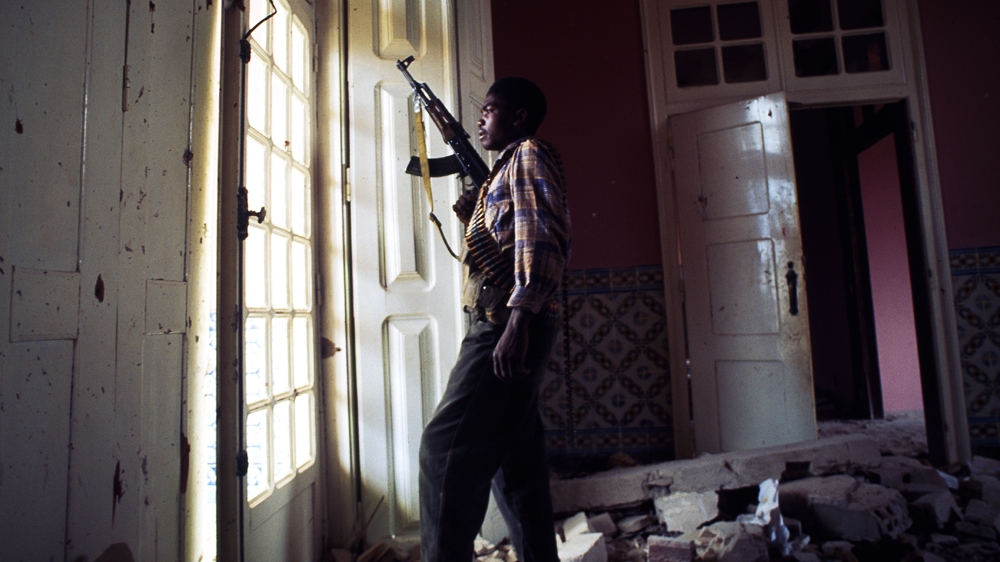 A rebel soldier surveys government troop movements during a lull in the fighting in Quito, Angola. I remember how still and silent it felt; even the birds were quiet. But, instead of seeming peaceful, it felt ominous. 1993 [Jack Picone] 