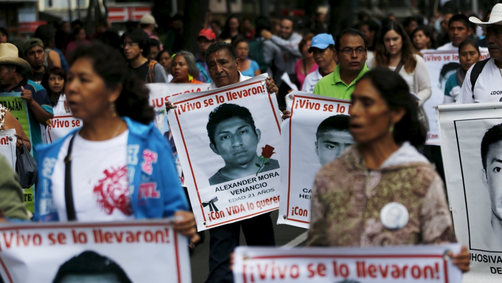 Relatives carry photos of some of the 43 missing students of the Ayotzinapa teachers'' training college during a protest to mark the eleven-month anniversary of their disappearance in Mexico City