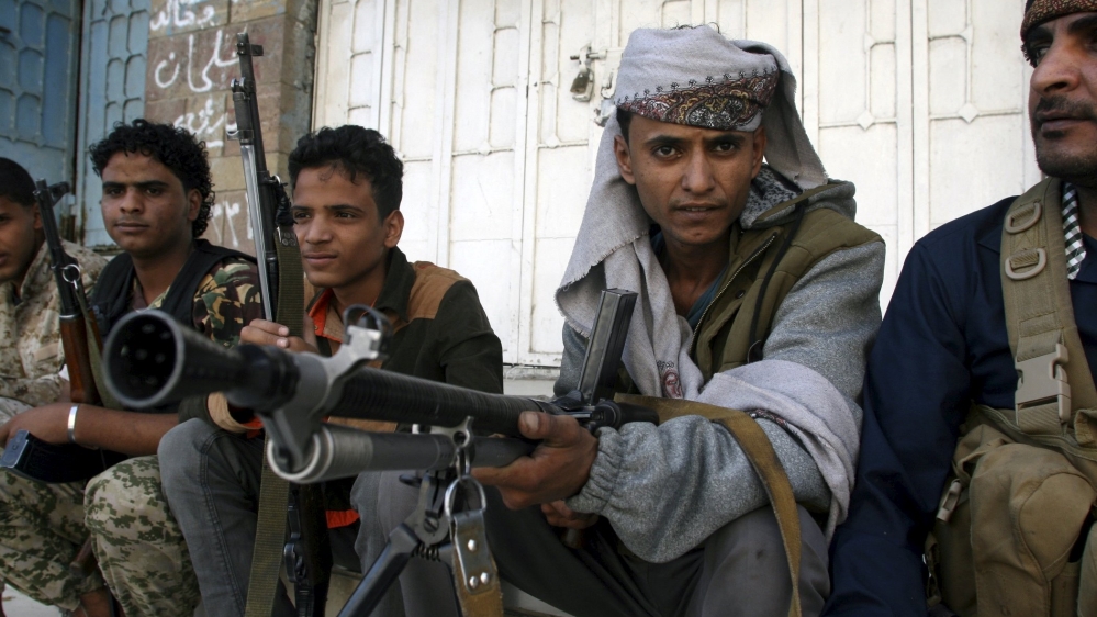 Pro-government militants sit on the side of a street where they fight against Houthi militia men in Yemen''s southwestern city of Taiz