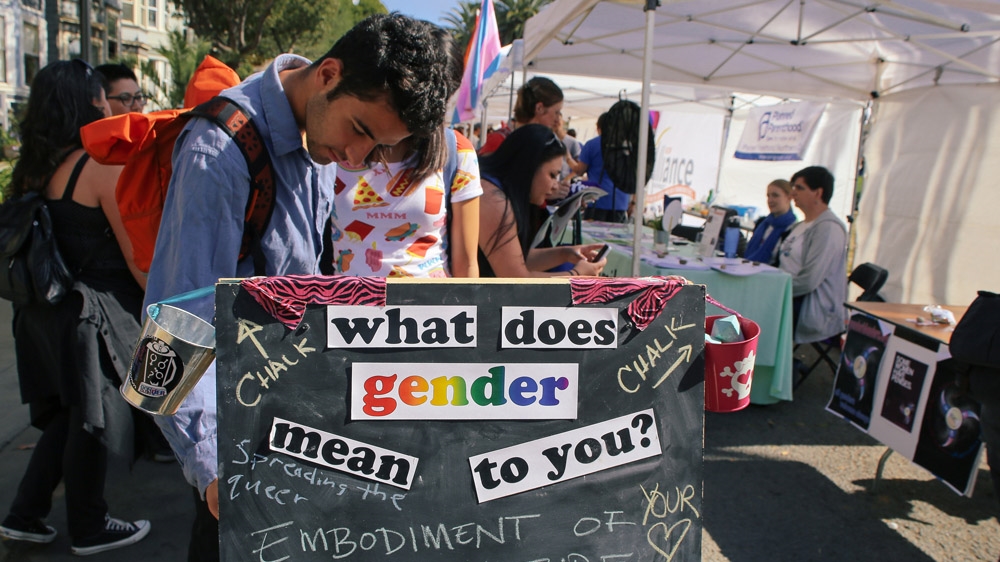 A billboard at a trans parade highlights the fluidity of gender identity [Amanda Harris]