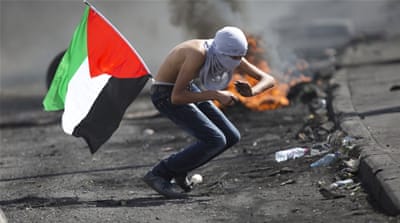 A Palestinian tries to dodge rubber-coated bullets during clashes with Israeli troops near Ramallah, West Bank [AP]