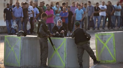 Israeli border police check Palestinians' IDs at a checkpoint as they exit the Arab neighbourhood of Issawiya in Jerusalem [AP]
