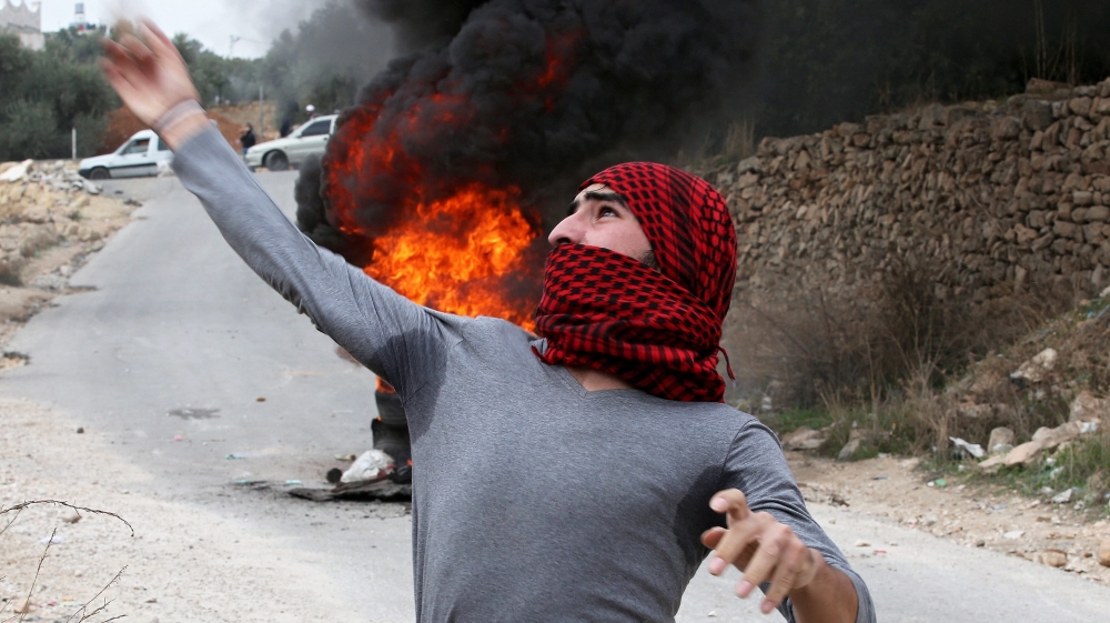 Palestinian protesters throw stones at Israeli soldiers during clashes in the West Bank city of Hebron [EPA]